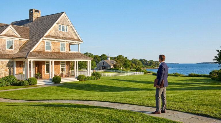 Un agent immobilier regarde une luxueuse villa en bois avec jardin face à l'océan.